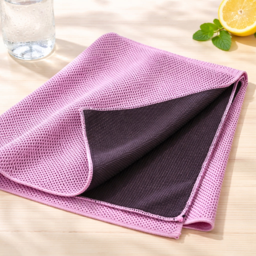Pink or purplish cooling towel on a wooden surface with a glass of water and lemon.
