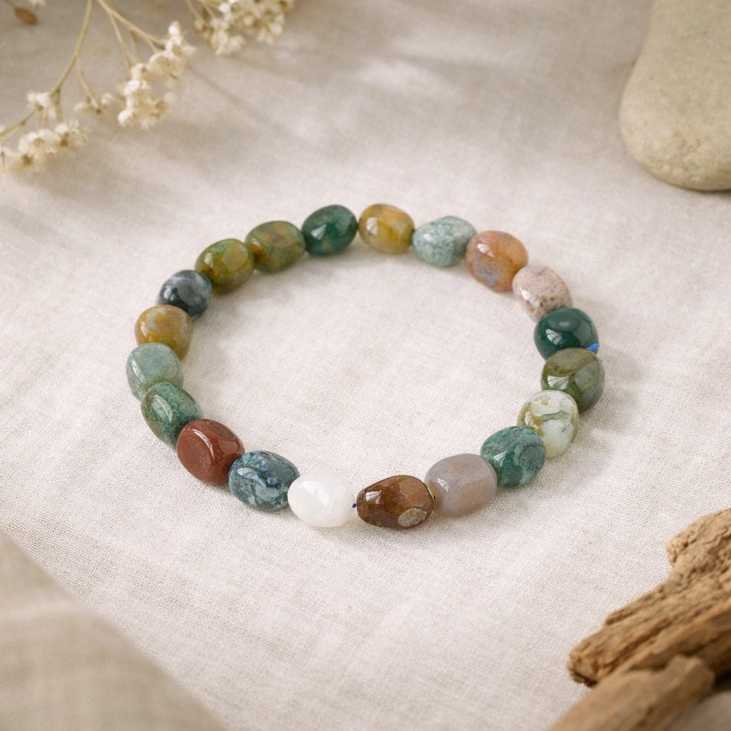 Multicolored beaded bracelet on a textured surface with natural elements.