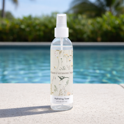 Bottle of hydrating toner with a floral label by a pool