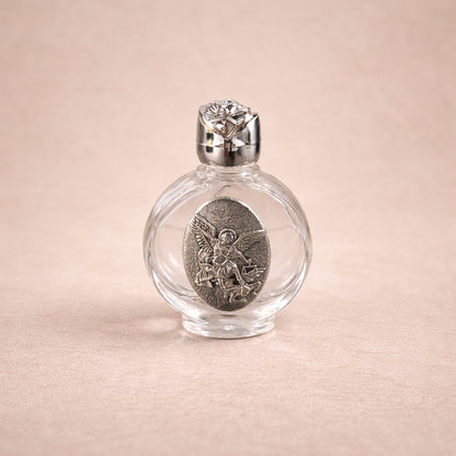 Clear glass bottle with silver cap and decorative label on a beige background